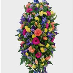 Vibrant seasonal casket arrangement